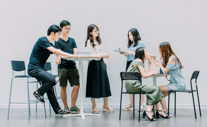 A group of young people sitting and standing