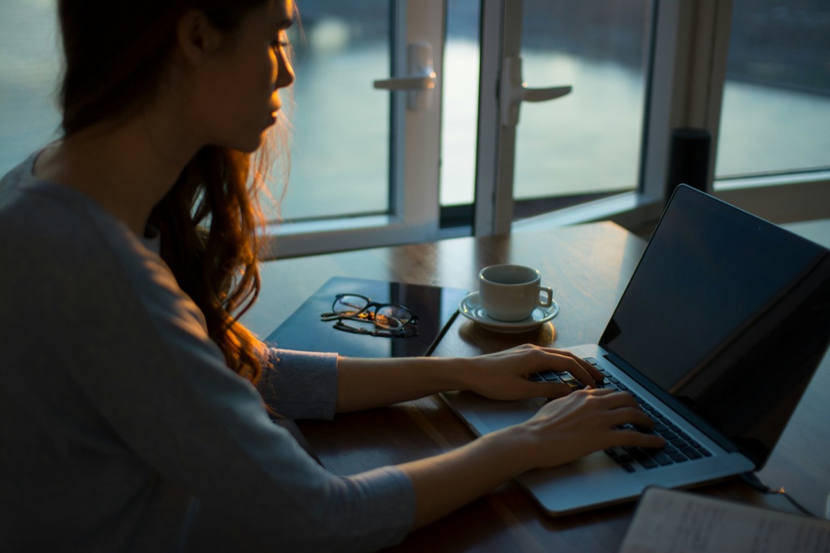 An engineer working alone at a laptop in the evening