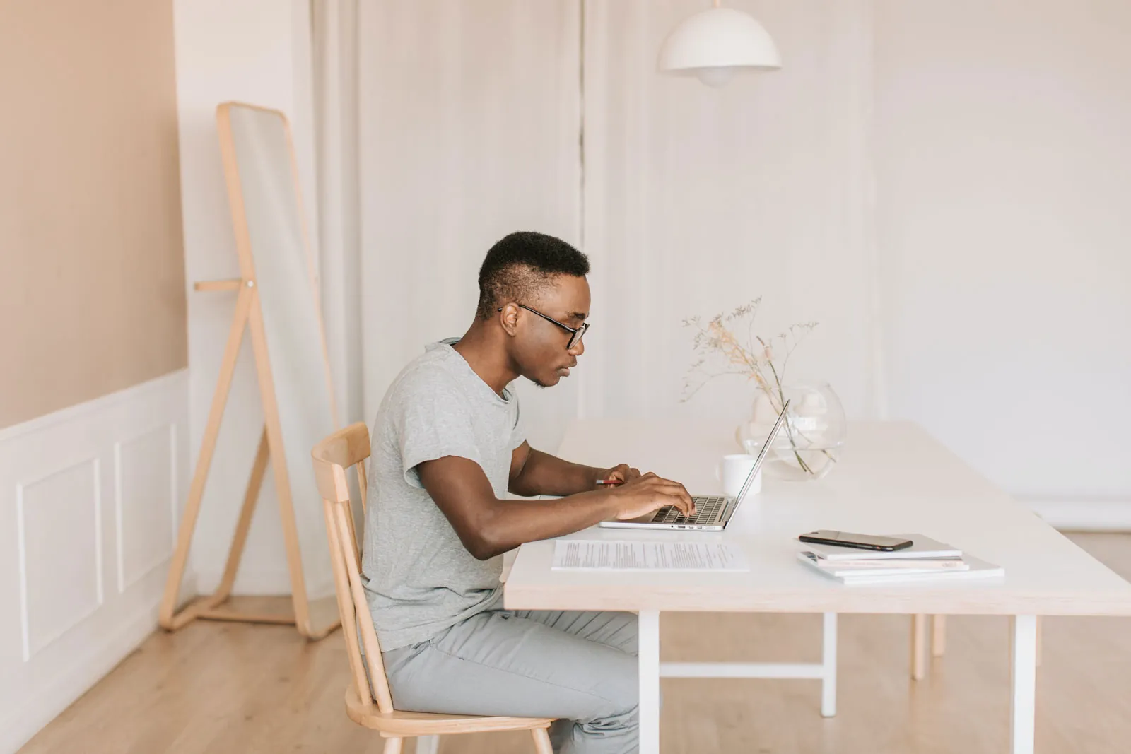 A man in glasses sitting in front of a laptop