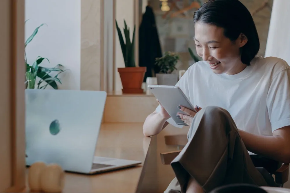 Woman looking on her tablet and smiling