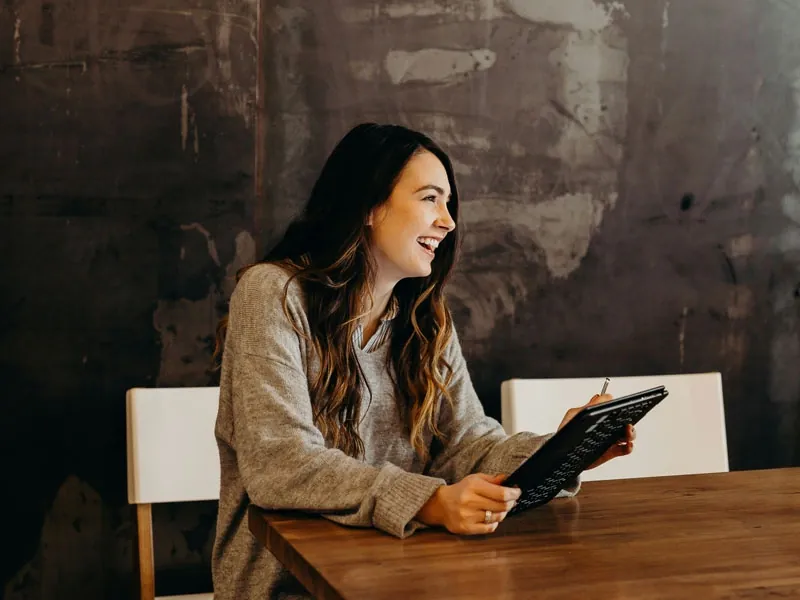 Woman looking on her tablet and smiling