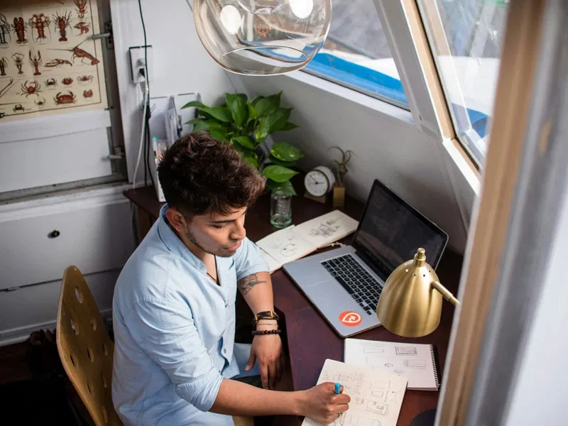 Man working on a computer in a cozy space