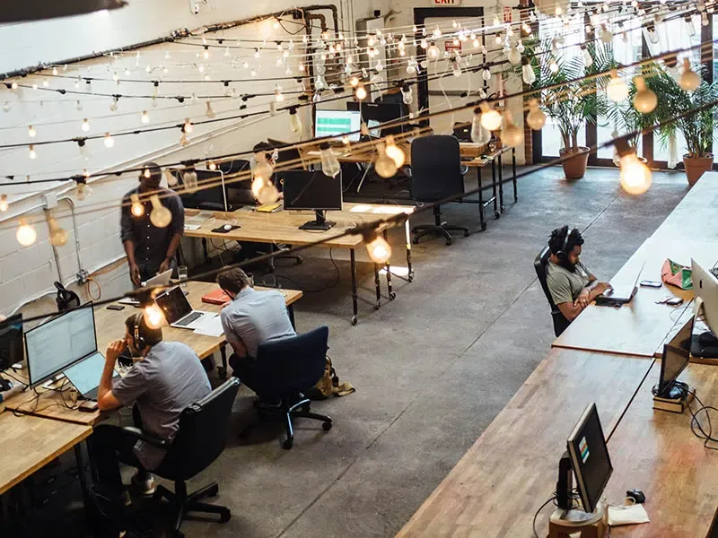 A co-working space with light bulbs under the ceiling