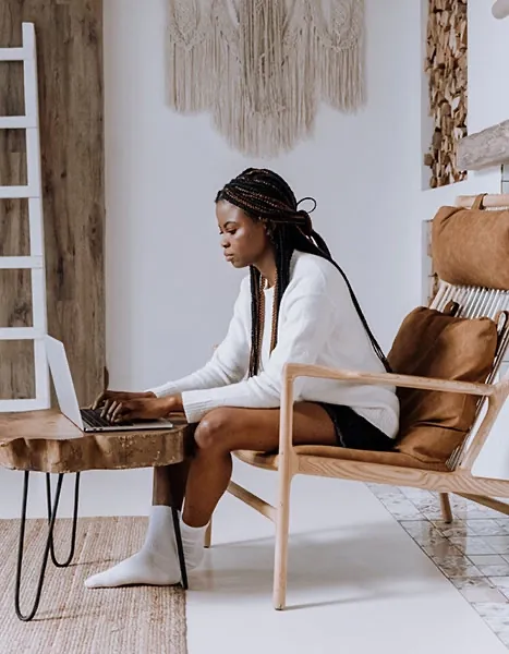 A woman sitting in a chair in front of a laptop