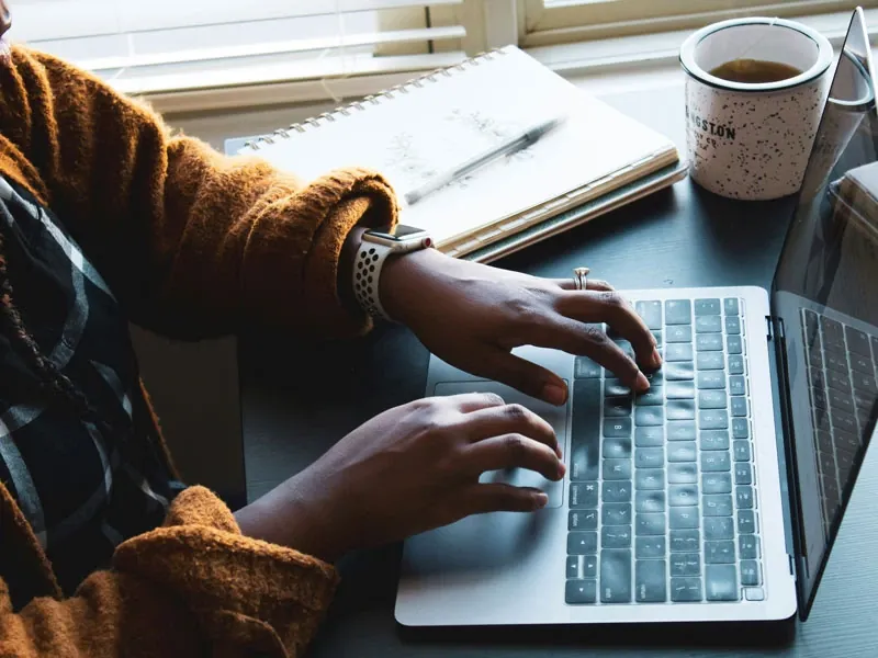 Woman sitting a desk in front of a laptop